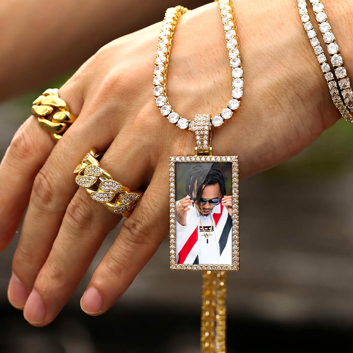 Person holding rectangle iced out picture pendant necklace