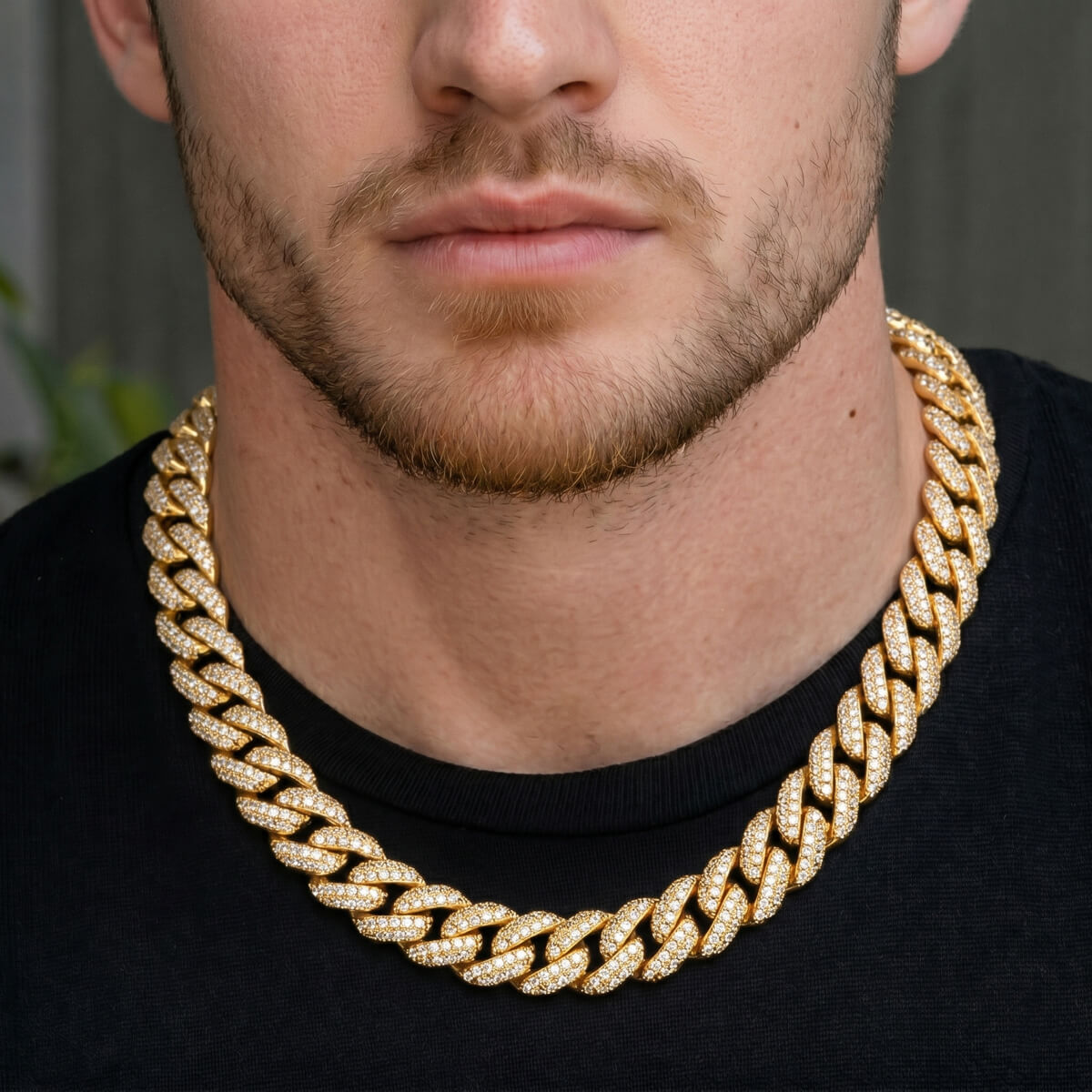 Man wearing a gold chain necklace against a neutral background