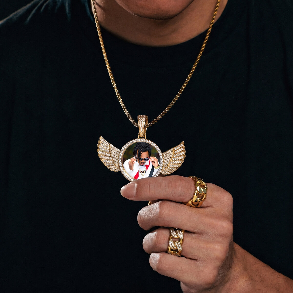 Person wearing circle chain with wings pendant