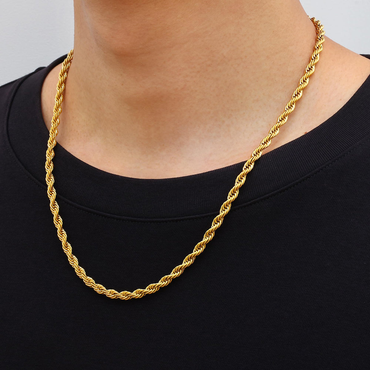 person wearing gold stainless steel rope chain necklace