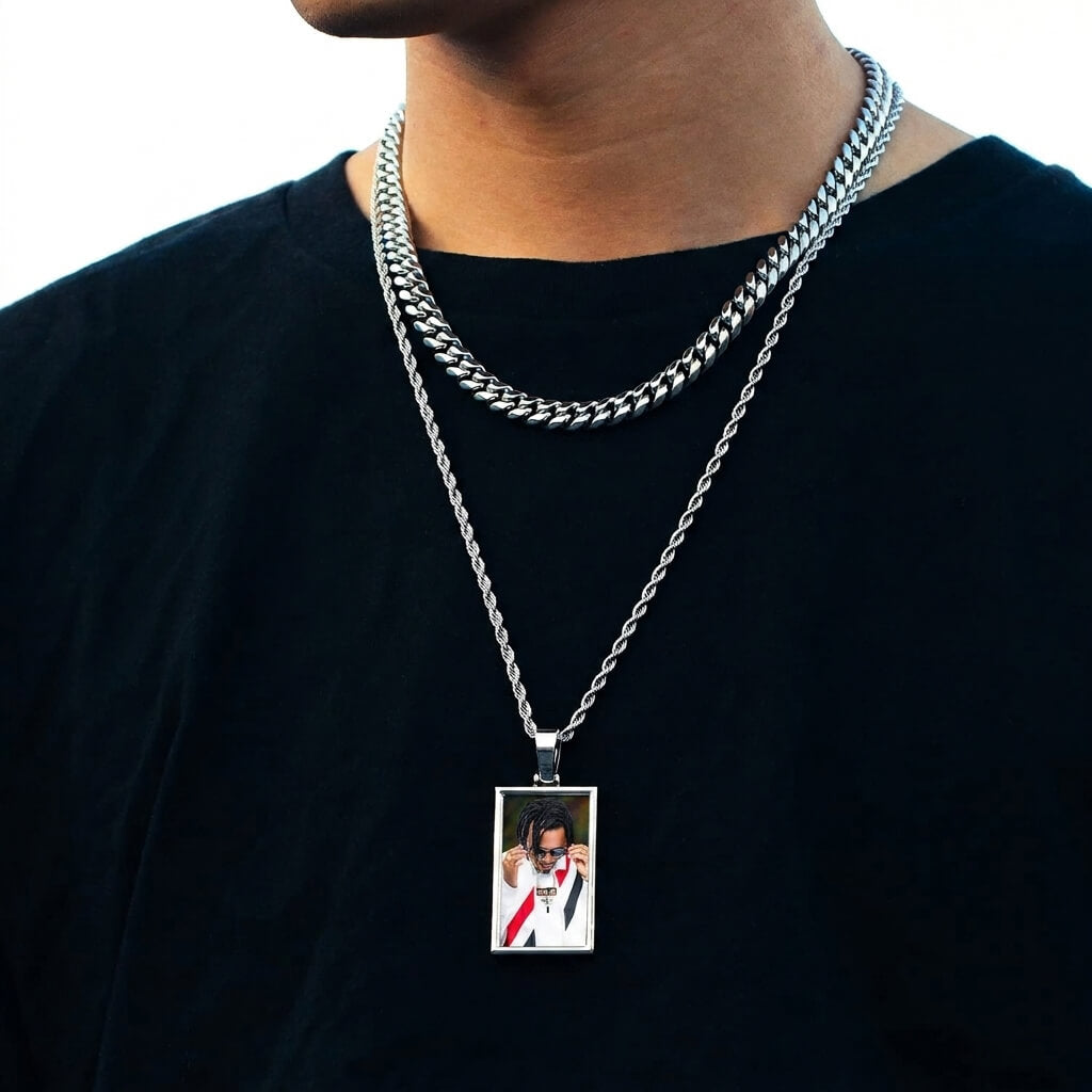 Person wearing a silver chain necklace with a pendant , chain with picture pendant
