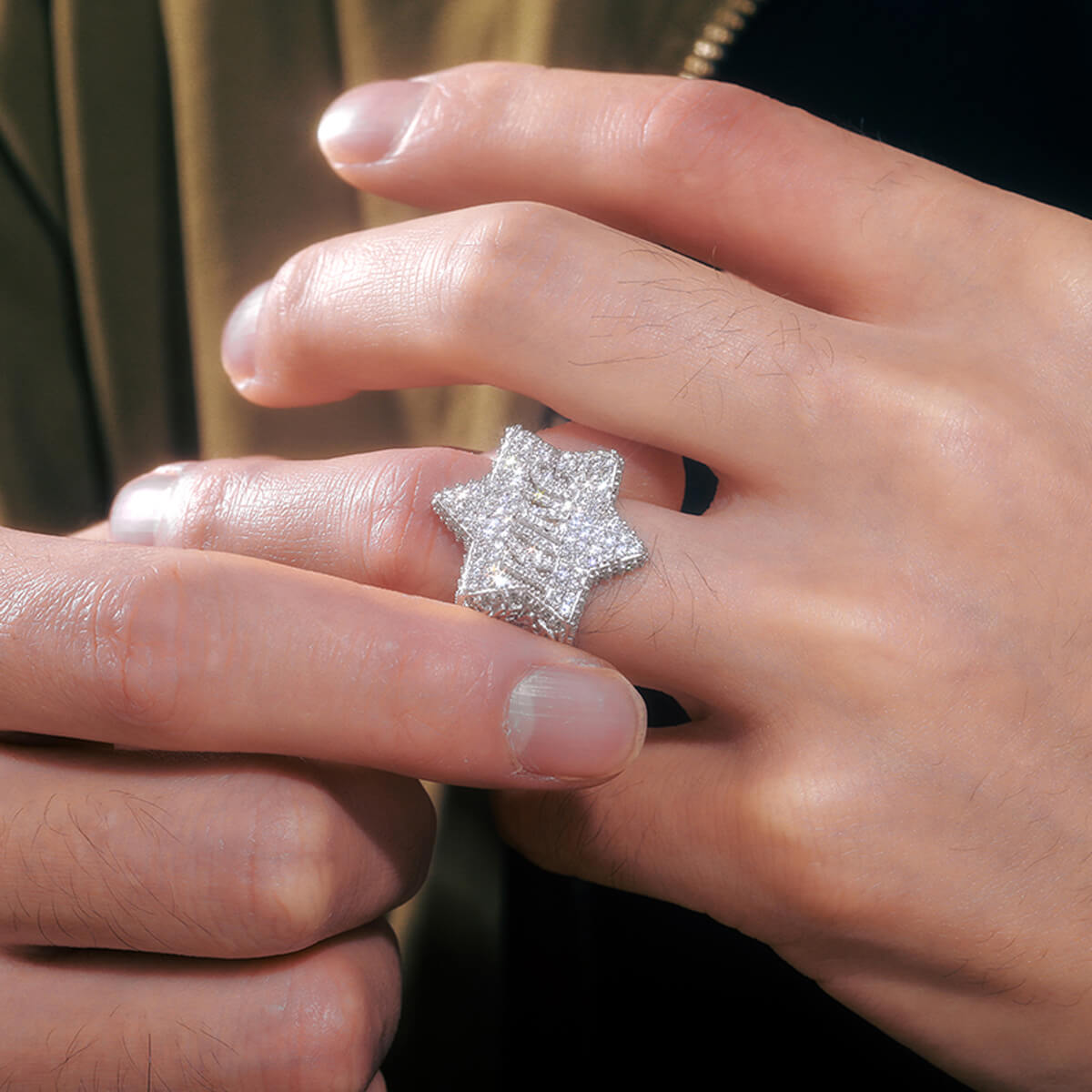 Close-up of King Iced Out Five Star Ring on finger in silver with brilliant Moissanite or CZ stones.