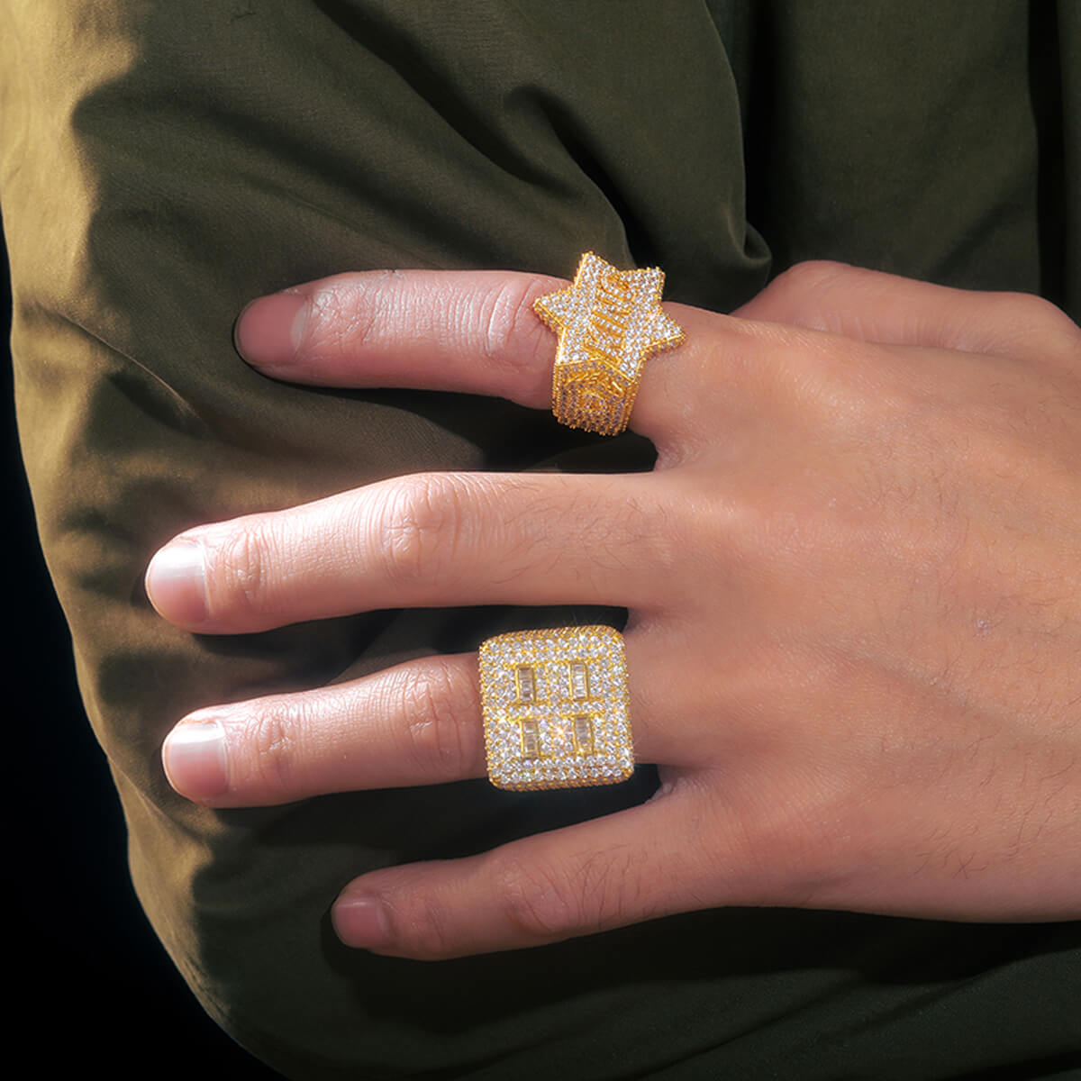Man wearing King Iced Out Five Star Ring in gold with brilliant stones and luxury streetwear jewelry style.