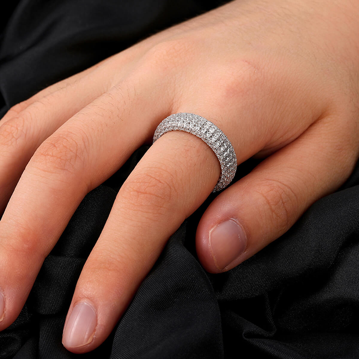 Close-up of Rapper Chains 6mm Micro Pave Engagement Ring on finger featuring white Moissanite stones in sterling silver setting