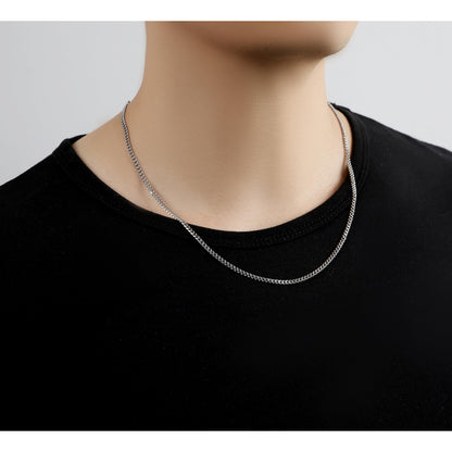 person wearing silver stainless steel Cuban chain necklace